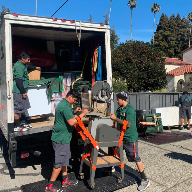 Four Men Standing Infront of a Moving Truck