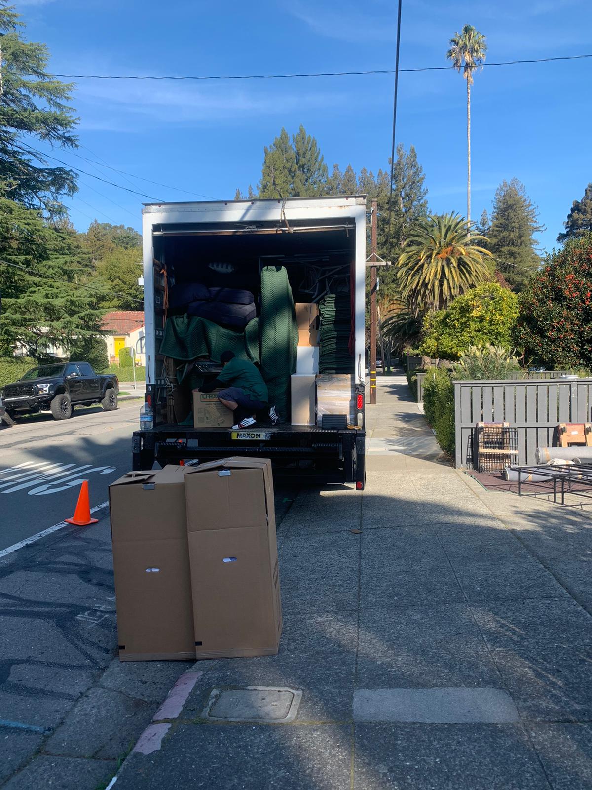 Moving boxes with clothes in them on a marble floor.