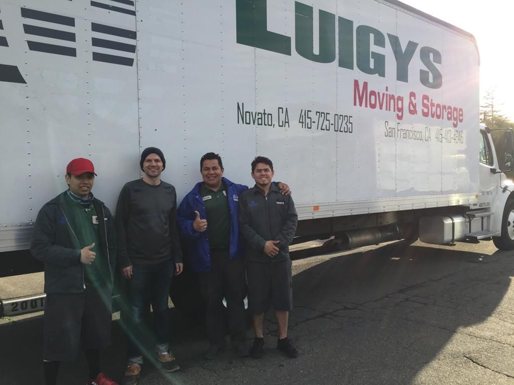 Four Men Standing Infront of a Moving Truck